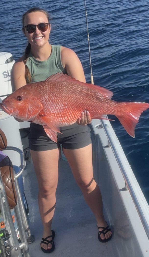 Angler holding a red snapper aboard the boat on an earlier trip