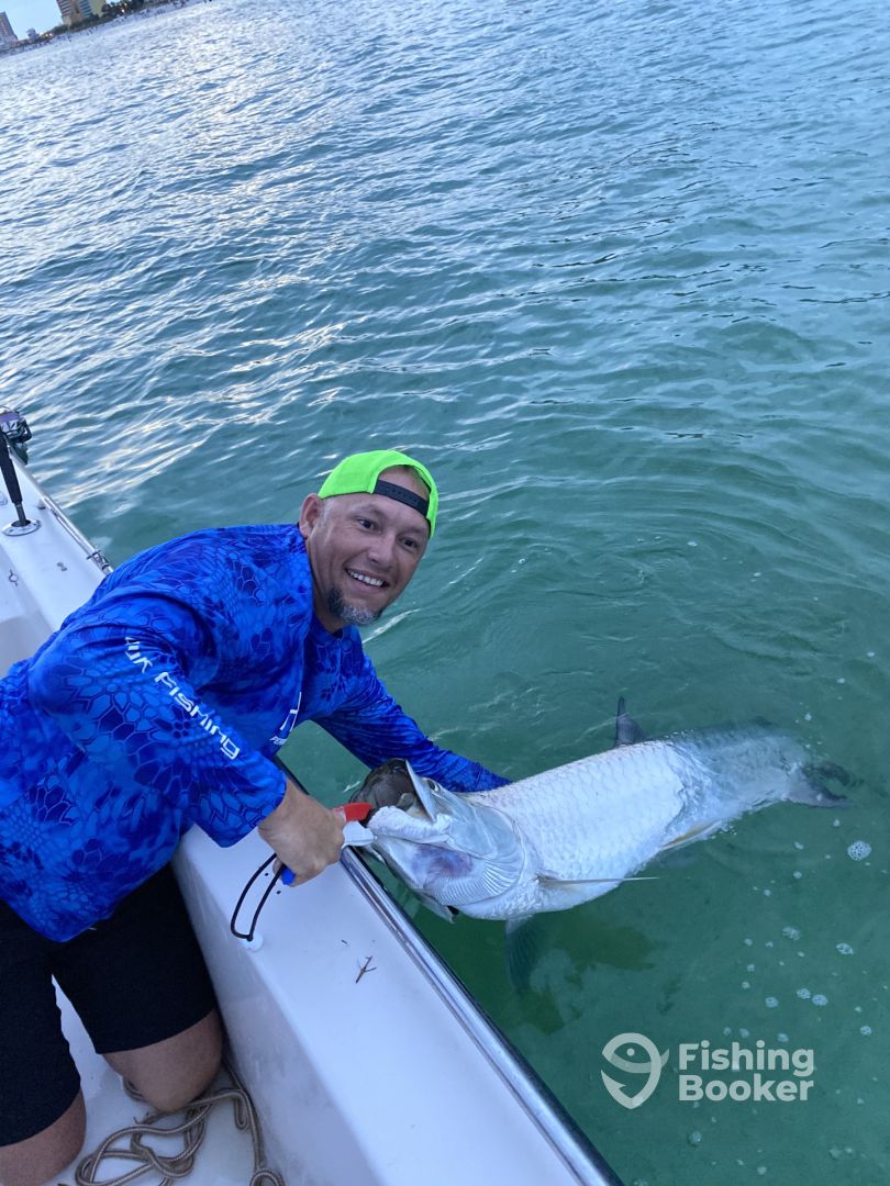 Angler fighting a fish from a boat in a coastal waterway